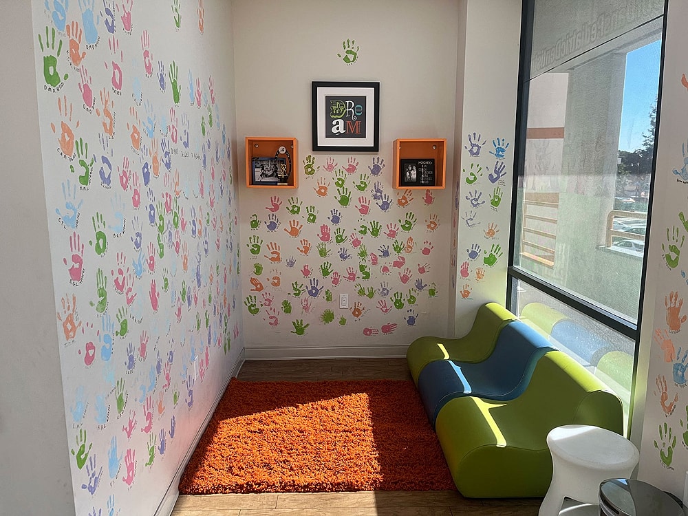 Colorful handprint wall in a cozy corner.