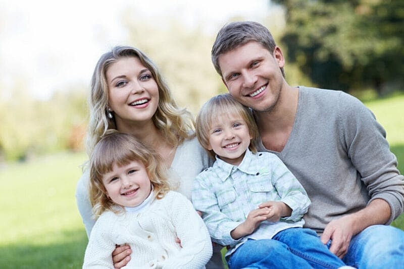 young couple smiling with children
